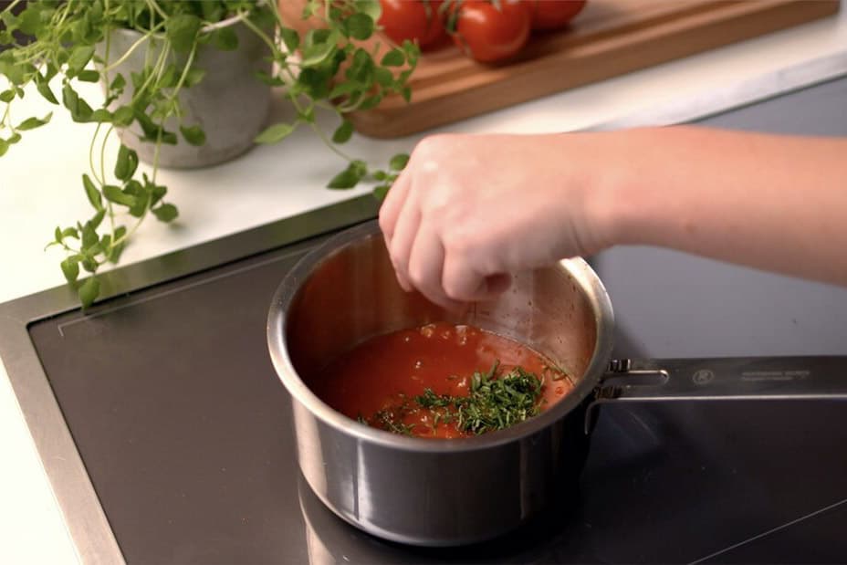 Kastrull med tomatsås och kryddor i